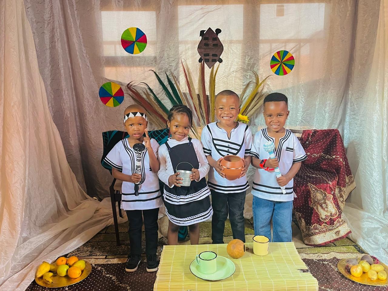 Four children in black and white traditional outfits for Heritage Day
